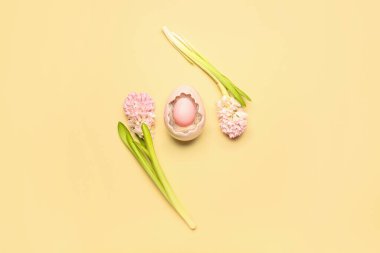 Composition with beautiful hyacinth flowers and Easter egg in decorative basket on beige background