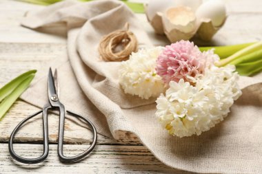 Sümbül çiçekleri, Paskalya yumurtaları, iplik ve makas beyaz ahşap arka planda