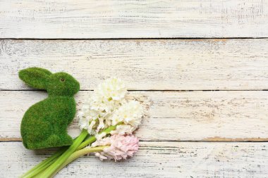 Güzel sümbül çiçekleri ve beyaz ahşap arka planda tavşan.