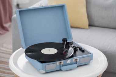 Oturma odasındaki masada vinil diski olan kayıt çalar, yakın plan.