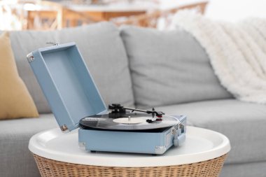 Oturma odasındaki masada vinil diski olan kayıt çalar, yakın plan.