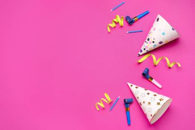 Renkli arka planda parti şapkaları, ıslıklar, mumlar ve yılan balıklarıyla kompozisyon