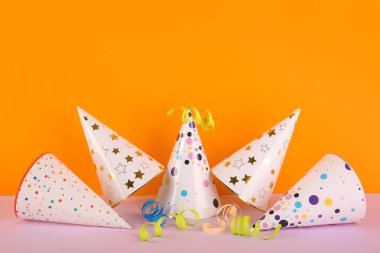 Renkli arka planda parti şapkaları ve yılanbalığıyla kompozisyon