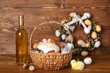 Paskalya yumurtası, pasta ve ahşap arka planda bir şişe şarap.