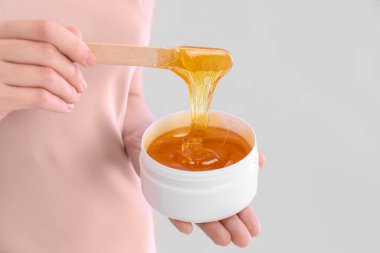 Hafif arka planda şekerleme yapıştırıcısı olan kadın, yakın plan