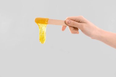 El ele tutuşma spatulası ve hafif arka planda şekerleme macunu.