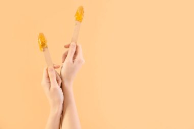 Bej arka planda şekerli spatula tutan kadın elleri