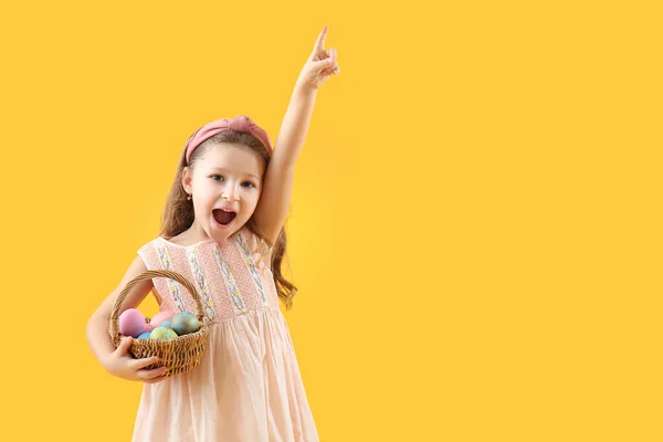Paskalya Yumurtası Dolu Sepetli Şirin Küçük Kız Sarı Arka Planda — Stok fotoğraf