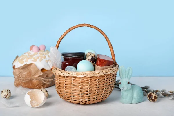 Kosz Jajkami Wielkanocnymi Szynką Króliczkiem Szarym Stole Niebieskim Tle — Zdjęcie stockowe