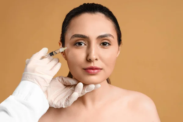 Genç Bir Kadın Bej Arka Planda Yüzlerine Enjeksiyon Yaptırıyor — Stok fotoğraf