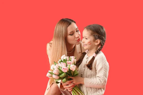 Милая Маленькая Девочка Приветствует Свою Мать Тюльпанами Красном Фоне — стоковое фото