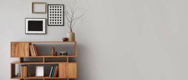 Kitapları ve dekorasyonu olan raf ünitesi odada ışık duvarının yanında. Tasarım için pankart