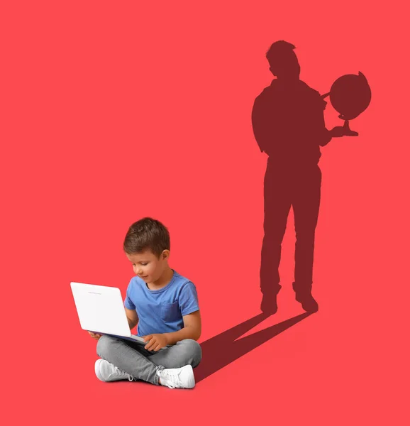 Boy with laptop and silhouette of teacher on red background