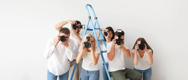 Grupo Jóvenes Fotógrafos Con Cámaras Fotográficas Sobre Fondo Claro — Foto de Stock