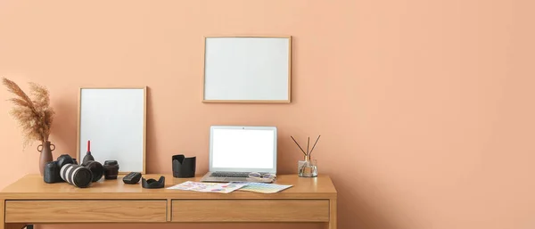 ノートパソコン 現代的なデバイスとベージュの壁の近くに空白のフレームを持つ写真家の職場 デザインのバナー — ストック写真