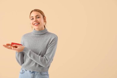 Bej arka planda vitamin takviyeleri olan güzel bir genç kadın.