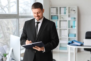 Male accountant with notebook in office