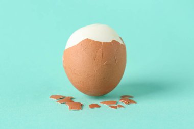 Turkuaz arka planda soyulmuş yumurta.