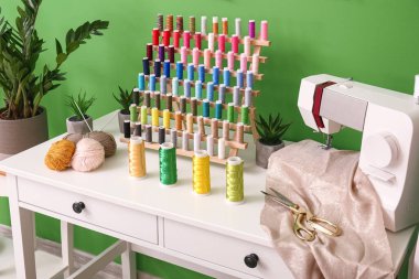Atölyede dikiş makinesi ve iplik makaralarıyla terzinin işyeri