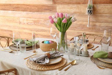 Yemek odasında çiçekler ve mumlarla güzel bir Paskalya masası.