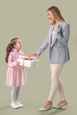 Sevimli küçük kız yeşil arka planda annesini hediyeyle selamlıyor.