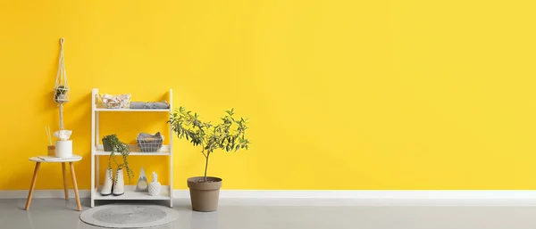 黄色の壁の近くの棚ユニット上の服やアクセサリーとモダンな廊下のインテリア デザインのバナー — ストック写真