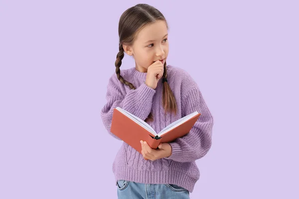 Little Girl Book Biting Nails Lilac Background — Stock fotografie