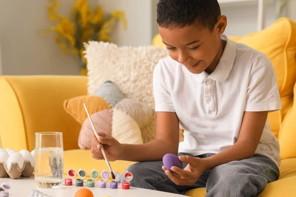 stock image Little African-American boy painting Easter egg at home