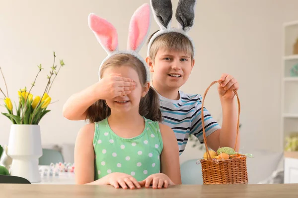 妹の目を閉じキッチンでイースターの卵のバスケットと男の子 — ストック写真