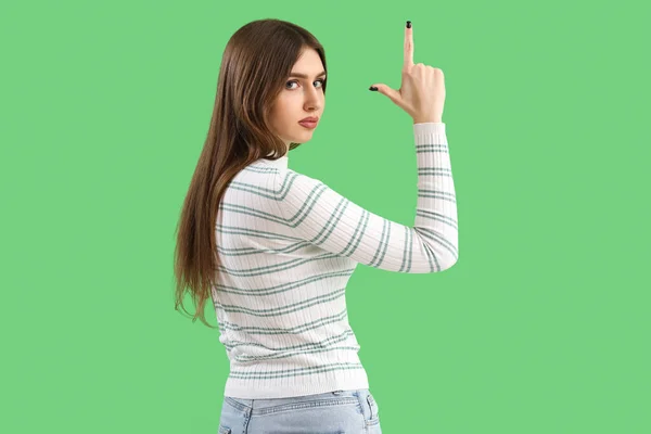Ung Kvinna Visar Förlorare Gest Grön Bakgrund — Stockfoto