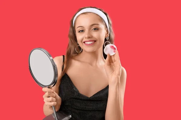 Mujer Joven Con Espejo Quitando Maquillaje Sobre Fondo Rojo — Foto de Stock