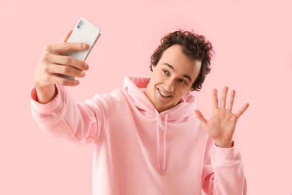 Cep Telefonlu Genç Adam Pembe Arka Planda Selfie Çekiyor — Stok fotoğraf