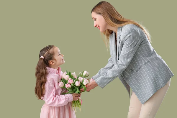 可爱的小女孩用绿色背景的郁金香问候她的母亲 — 图库照片