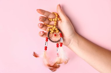 Pembe arka planda güzel bir düş kapanı olan kadın.