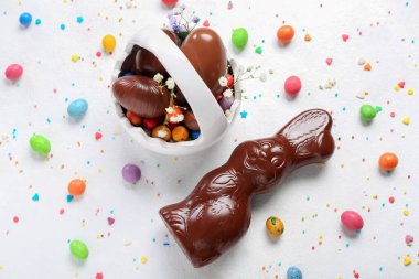 Beyaz arka planda sepet ve yumurtalı Paskalya tavşanı.