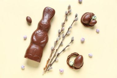 Yumurtalı ve sarı arka planda söğüt dallı Paskalya tavşanı.