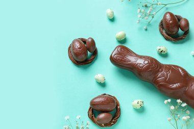 Renkli arka planda yumurta ve çiçekli Paskalya tavşanı, yakın plan.