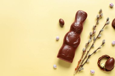 Yumurtalı ve sarı arka planda söğüt dallı Paskalya tavşanı.