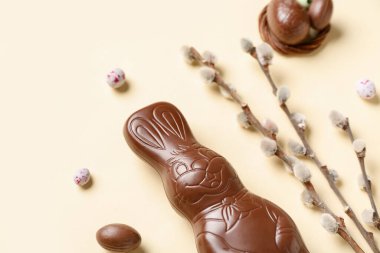 Yumurtalı ve sarı arka planda söğüt dallı Paskalya tavşanı.