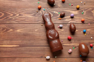 Çikolatalı Paskalya tavşanı. Tahta arka planda yumurtalar ve serpiştirilmiş.