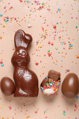 Çikolatalı Paskalya tavşanı. Bej arka planda yumurtalar ve serpiştirilmiş.