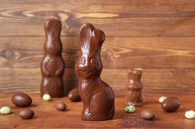 Tahta arka planda yumurtaları olan Paskalya tavşanları, yakın plan.