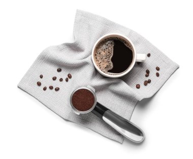 Beyaz arka planda kahve tozu, fasulye, bardak ve peçete ile kepçe