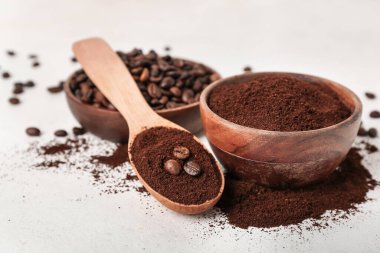 Kaşık dolusu kahve tozu ve beyaz arka planda fasulye, yakın plan.