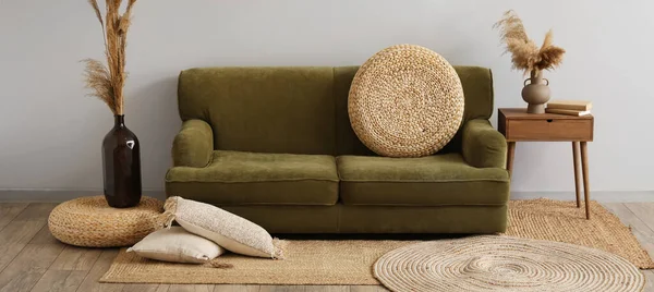 轻便客厅内饰绿色沙发 柳条地毯及花卉装饰 — 图库照片
