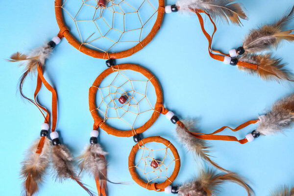Beautiful dreamcatcher on blue background, closeup