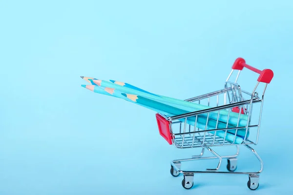 Mavi Arka Planda Kalemleri Olan Alışveriş Arabası — Stok fotoğraf