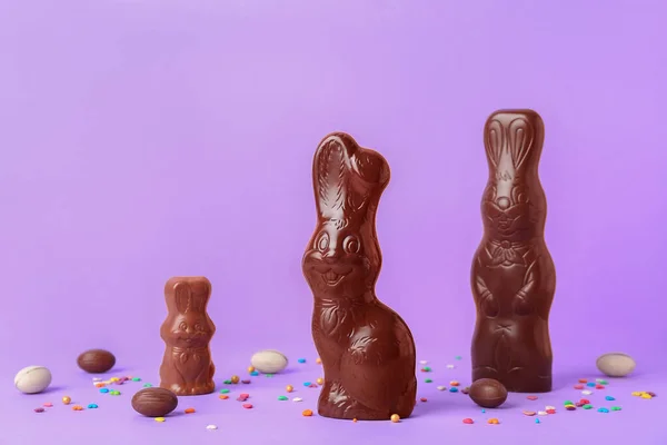 Choklad Påsk Kaniner Med Ägg Och Strössel Lila Bakgrund — Stockfoto