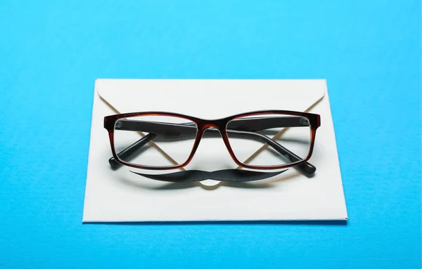 Umschlag Mit Papierschnurrbart Und Brille Auf Farbigem Hintergrund Vatertagsfeier — Stockfoto