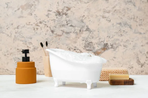 桌上有泡沫 海绵和肥皂的小浴缸 — 图库照片